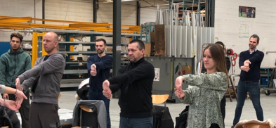 Des personnes en atelier réalisant un étirement des poignets. 