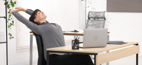 Personne qui s'étire devant son écran d'ordinateur