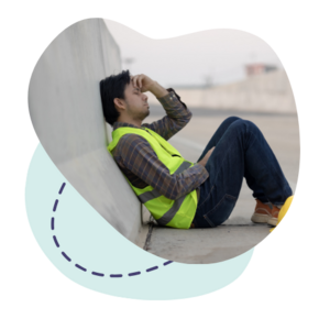 Travailleur en pause, assis avec une posture de fatigue, illustrant la réflexion sur la santé mentale au travail 