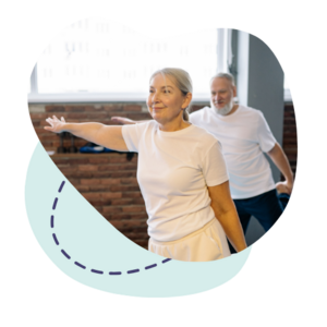 Deux personnes effectuent un exercice d’équilibre et d’étirement dans un espace intérieur dédié au bien‑être.